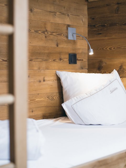 Pictures from Sportalm Single bed with white pillows and wooden wall in the background