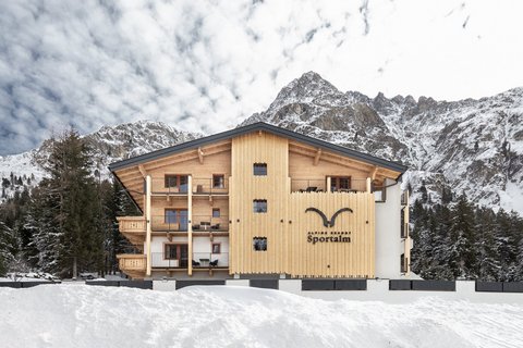 Bilder aus der Sportalm Alpenresort Sportalm vor verschneiten Bergen und Wald
