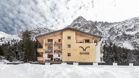Bilder aus der Sportalm Alpenresort Sportalm vor verschneiten Bergen und Wald
