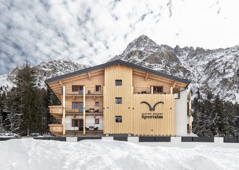 Bilder aus der Sportalm Alpenresort Sportalm vor verschneiten Bergen und Wald