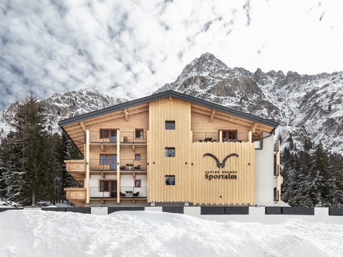 Bilder aus der Sportalm Alpenresort Sportalm vor verschneiten Bergen und Wald