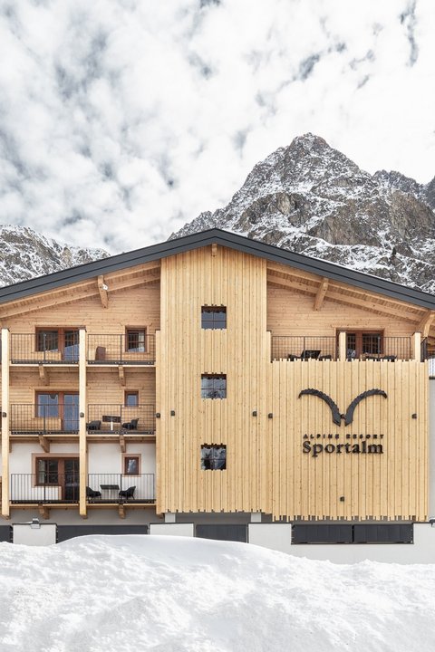Bilder aus der Sportalm Alpenresort Sportalm vor verschneiten Bergen und Wald