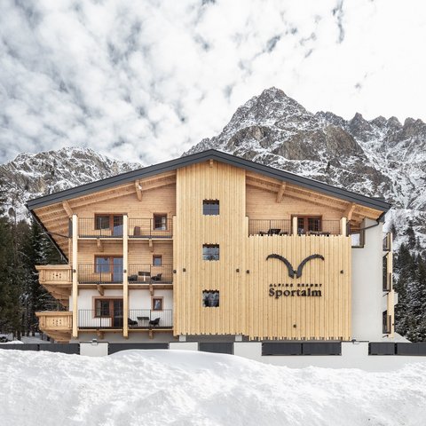 Bilder aus der Sportalm Alpenresort Sportalm vor verschneiten Bergen und Wald