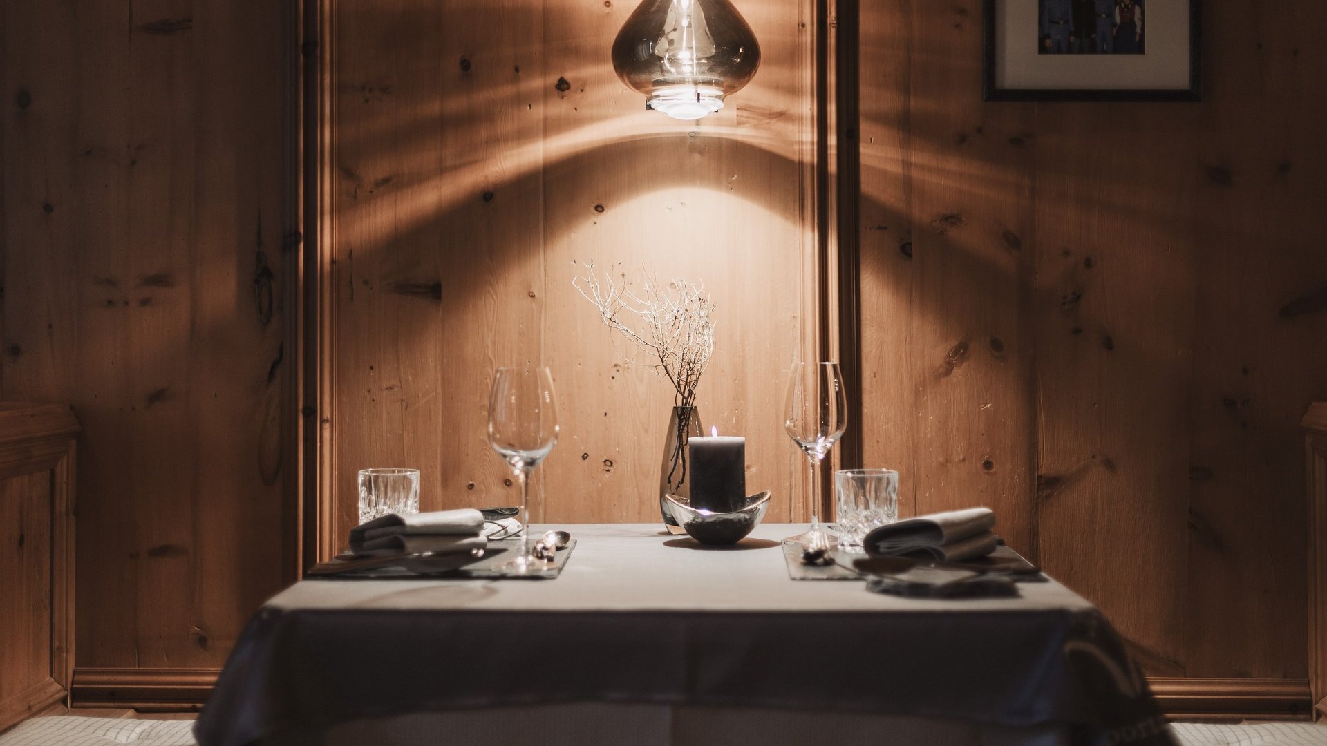 Freude schenken Küchentisch mit Kerze, Weingläsern und warmem Holz hinterlegt