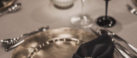 Pictures from Sportalm Elegant table setting with gold plate, black napkin, and candlelight