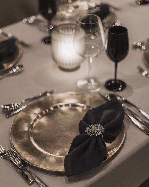 Pictures from Sportalm Elegant table setting with gold plate, black napkin, and candlelight