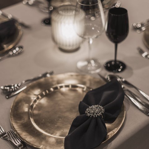 Pictures from Sportalm Elegant table setting with gold plate, black napkin, and candlelight