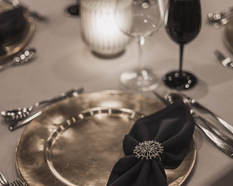 Pictures from Sportalm Elegant table setting with gold plate, black napkin, and candlelight