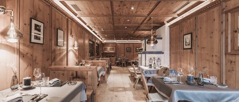 Bilder aus der Sportalm Rustikales Restaurant mit Holzvertäfelung und gedeckten Tischen