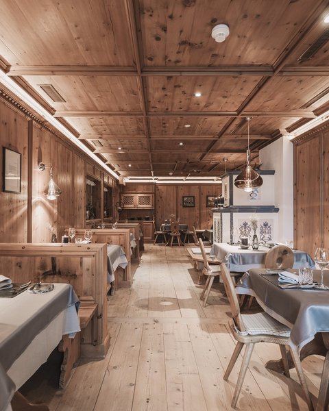 Pictures from Sportalm Rustic restaurant interior with wooden paneling and set tables