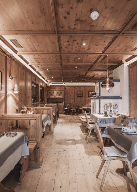 Bilder aus der Sportalm Rustikales Restaurant mit Holzvertäfelung und gedeckten Tischen