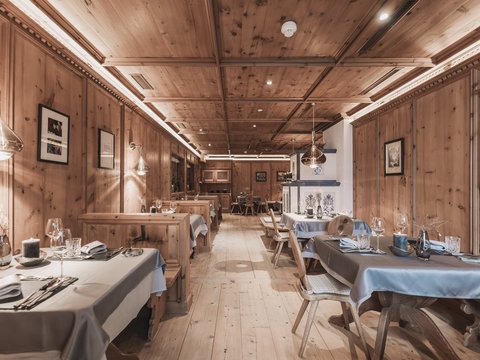 Bilder aus der Sportalm Rustikales Restaurant mit Holzvertäfelung und gedeckten Tischen