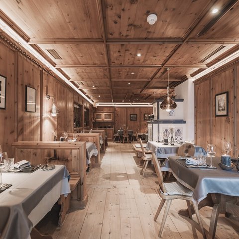 Bilder aus der Sportalm Rustikales Restaurant mit Holzvertäfelung und gedeckten Tischen