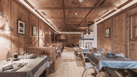 Pictures from Sportalm Rustic restaurant interior with wooden paneling and set tables