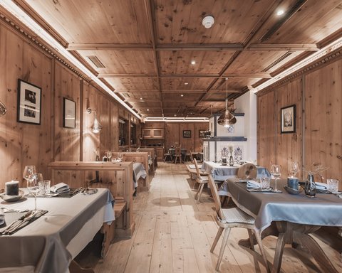 Pictures from Sportalm Rustic restaurant interior with wooden paneling and set tables