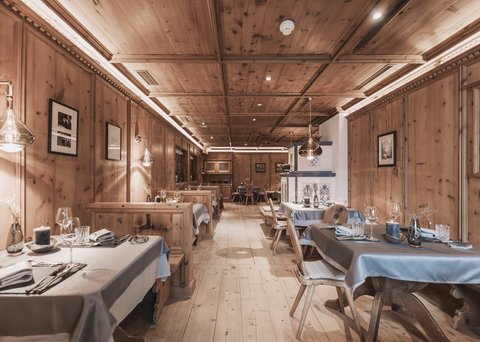 Bilder aus der Sportalm Rustikales Restaurant mit Holzvertäfelung und gedeckten Tischen