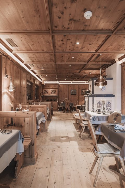 Bilder aus der Sportalm Rustikales Restaurant mit Holzvertäfelung und gedeckten Tischen