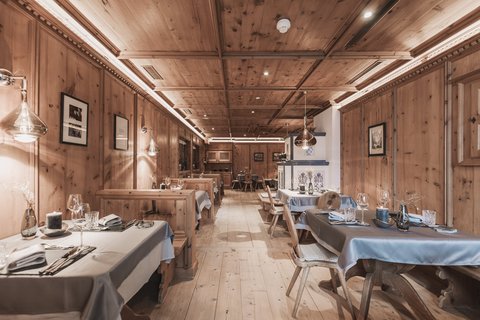 Bilder aus der Sportalm Rustikales Restaurant mit Holzvertäfelung und gedeckten Tischen