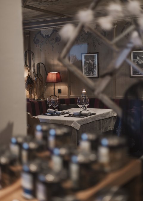 Cosy rooms in Pitztal Cozy restaurant table with candle, wine glasses, and red lamp in the background