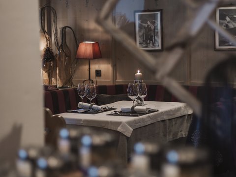 Pictures from Sportalm Cozy restaurant table with candle, wine glasses, and red lamp in the background