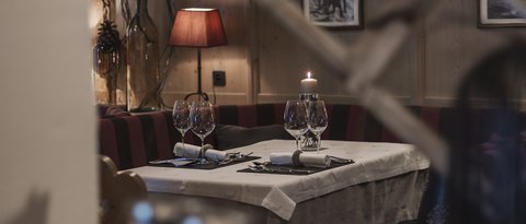 Pictures from Sportalm Cozy restaurant table with candle, wine glasses, and red lamp in the background