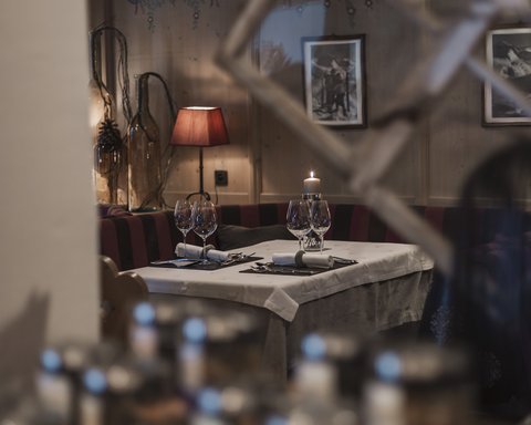 Pictures from Sportalm Cozy restaurant table with candle, wine glasses, and red lamp in the background