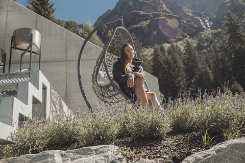 Pictures from Sportalm Woman relaxing in hanging chair by house with mountain view on a sunny day
