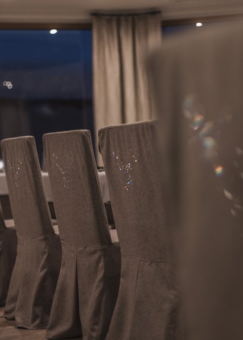 Pictures from Sportalm Row of gray covered chairs in a stylish dining room at night