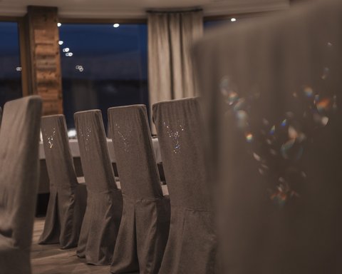 Pictures from Sportalm Row of gray covered chairs in a stylish dining room at night