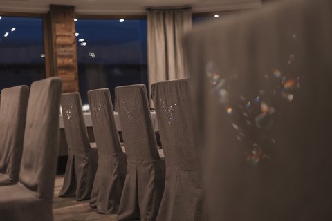 Pictures from Sportalm Row of gray covered chairs in a stylish dining room at night