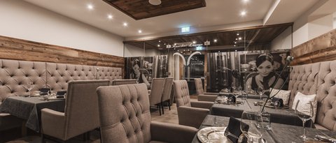 Bilder aus der Sportalm Eleganter Restaurantsaal mit bequemen Stühlen und gedeckten Tischen