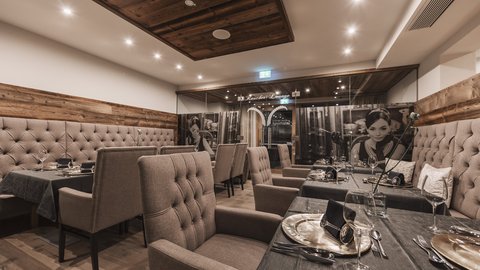 Bilder aus der Sportalm Eleganter Restaurantsaal mit bequemen Stühlen und gedeckten Tischen