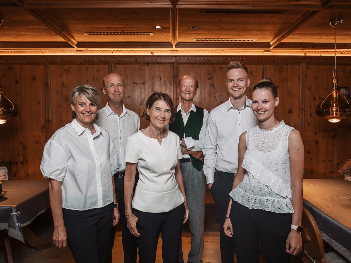A different kind of active holiday in Pitztal Six smiling people standing in front of a wooden wall in a rustic room