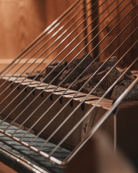 Bilder aus der Sportalm Saunaofen mit heißen Steinen und Schutzgitter aus Metall