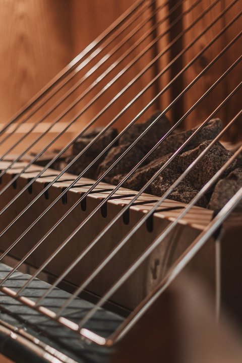 Bilder aus der Sportalm Saunaofen mit heißen Steinen und Schutzgitter aus Metall