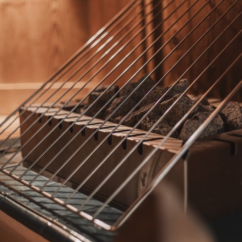 Bilder aus der Sportalm Saunaofen mit heißen Steinen und Schutzgitter aus Metall