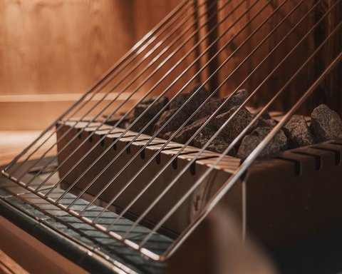 Bilder aus der Sportalm Saunaofen mit heißen Steinen und Schutzgitter aus Metall