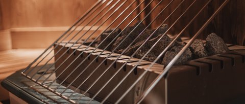 Bilder aus der Sportalm Saunaofen mit heißen Steinen und Schutzgitter aus Metall