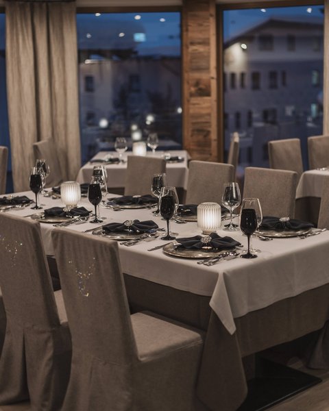 Bilder aus der Sportalm Elegantes Restaurant mit eingedeckten Tischen bei Abenddämmerung