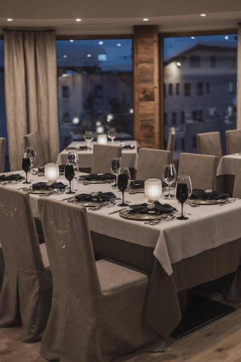 Bilder aus der Sportalm Elegantes Restaurant mit eingedeckten Tischen bei Abenddämmerung