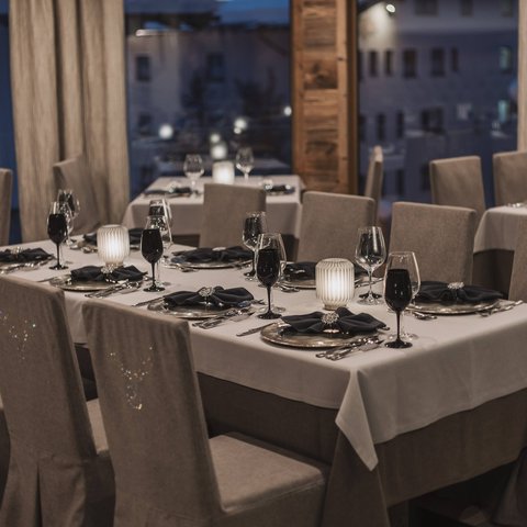 Bilder aus der Sportalm Elegantes Restaurant mit eingedeckten Tischen bei Abenddämmerung