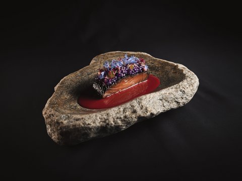 Unser Restaurant im Pitztal Fein angerichtetes Lachsgericht auf Felsenplatte mit roter Sauce und essbaren Blüten