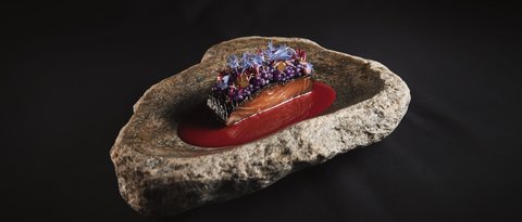 Pictures from Sportalm Gourmet salmon dish with red sauce and edible flowers on stone plate