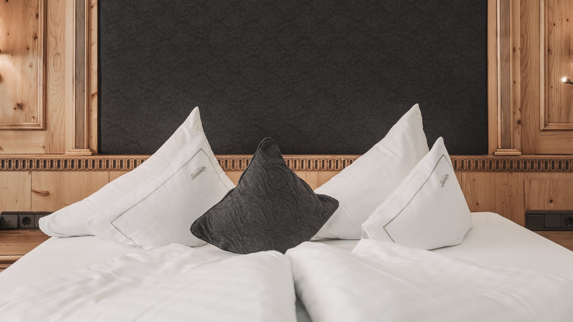 Freude schenken Gemütliches Bett mit Holzkopfteil und Wandlampen