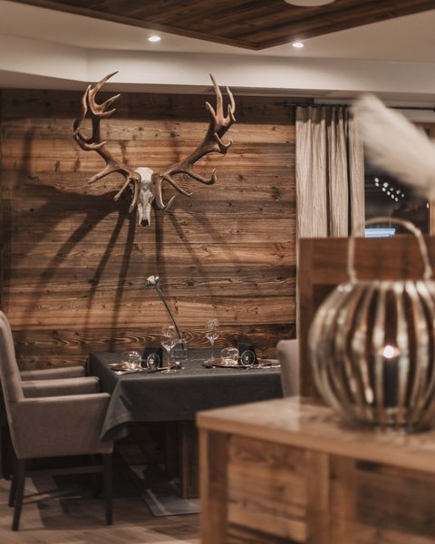 Pictures from Sportalm Cozy dining area with deer antlers on wooden wall and set table