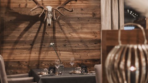 Pictures from Sportalm Cozy dining area with deer antlers on wooden wall and set table
