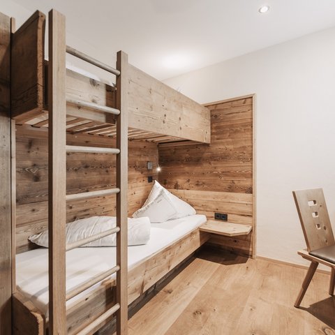 Pictures from Sportalm Small room with bunk bed and wooden paneling