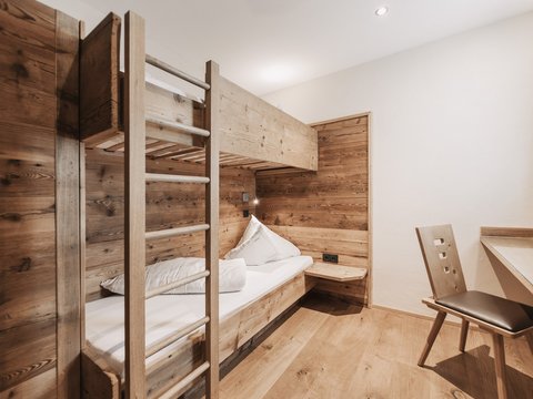 Bilder aus der Sportalm Kleines Zimmer mit Etagenbett und Holzverkleidung