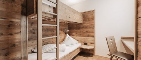 Bilder aus der Sportalm Kleines Zimmer mit Etagenbett und Holzverkleidung