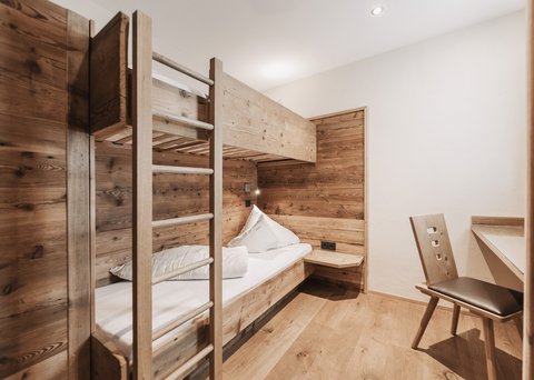 Bilder aus der Sportalm Kleines Zimmer mit Etagenbett und Holzverkleidung